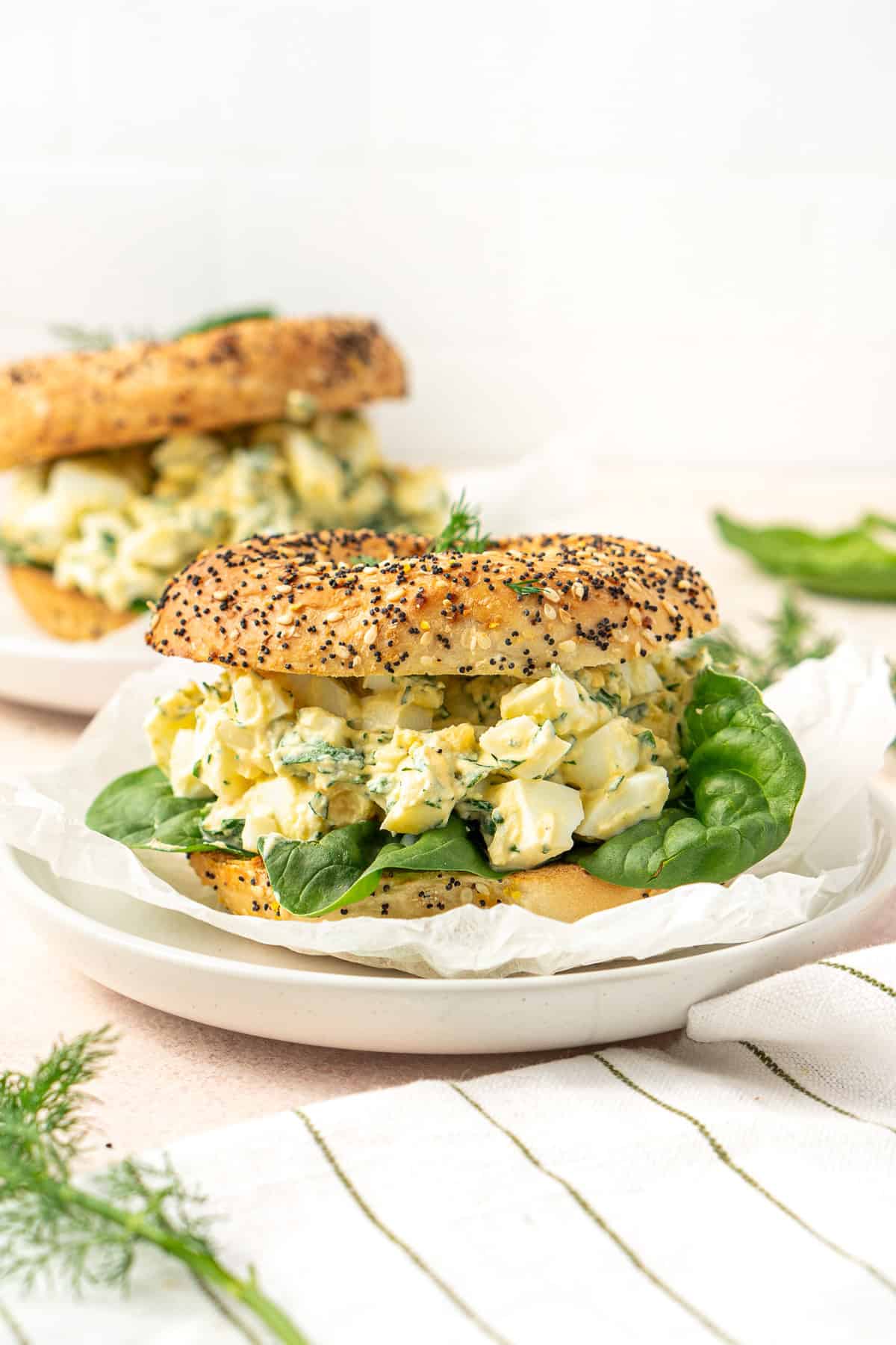 Healthy egg salad on a everything bagel with baby spinach.