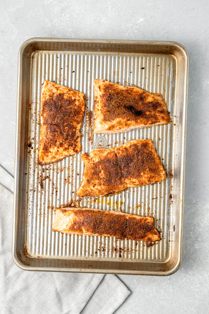 The grilled salmon on a baking tray.