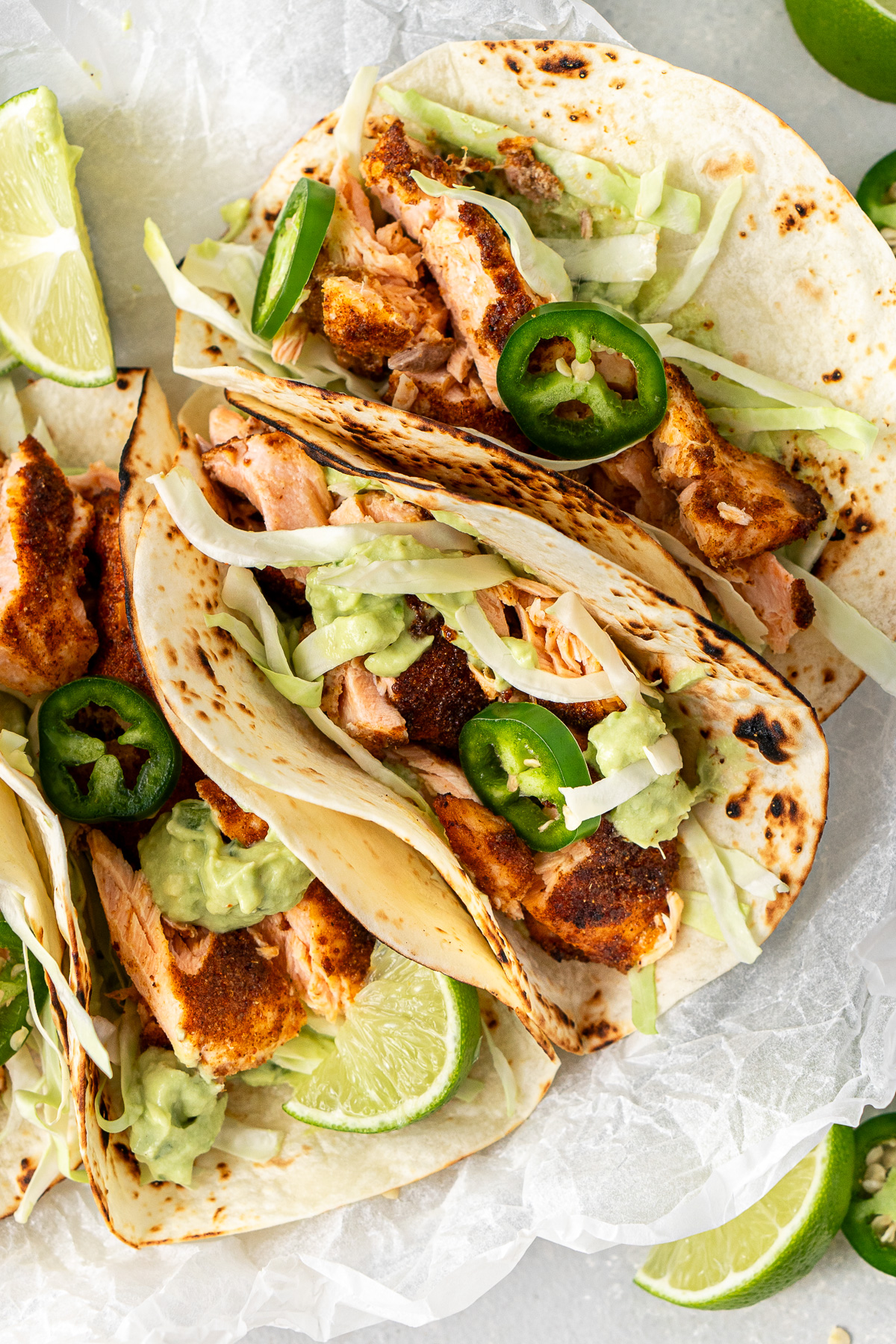 Close up of the salmon tacos with shredded cabbage, jalapenos and avocado crema. 