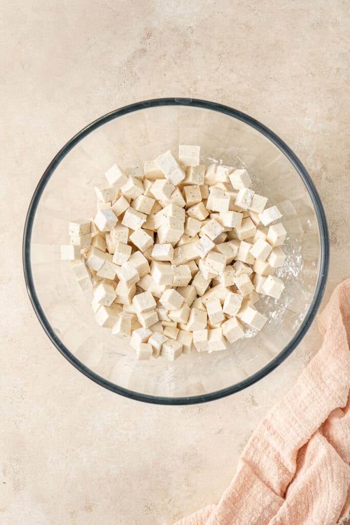 The cubed tofu in a mixing bowl with the cornflour.