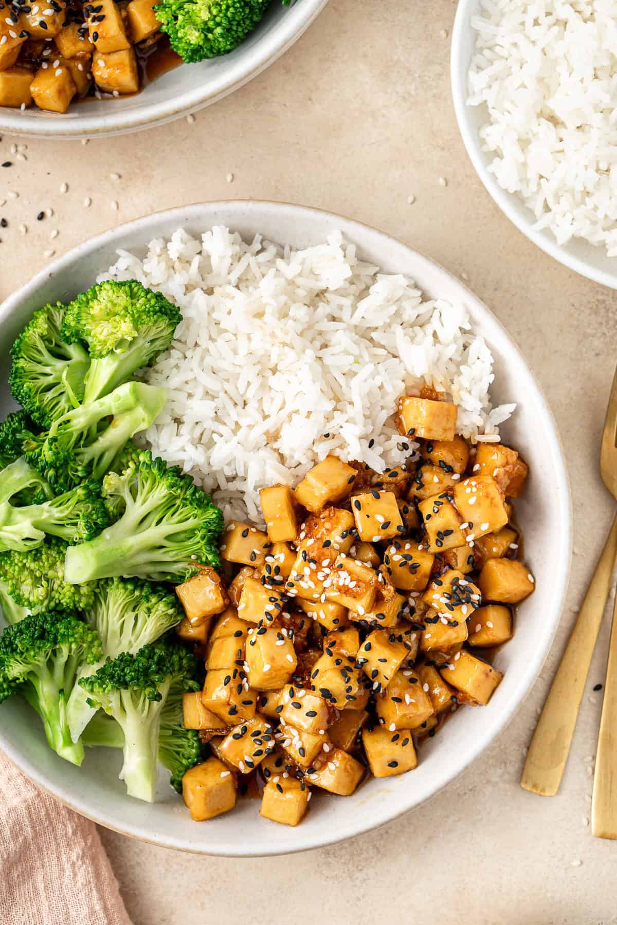 Close up of the honey garlic tofu served on a plate with rice and broccoli.