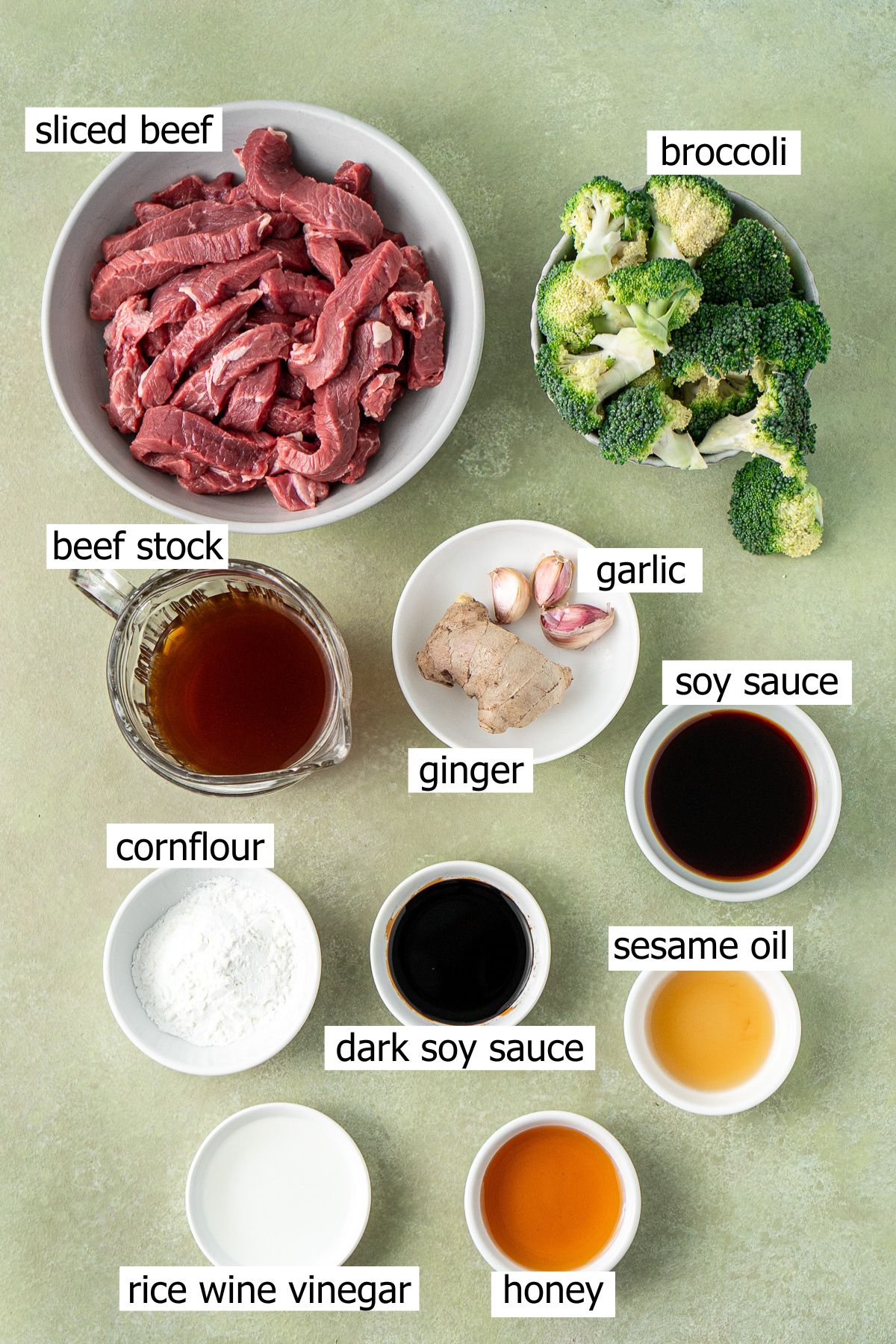 All ingredients needed to make beef and broccoli laid out in bowls.