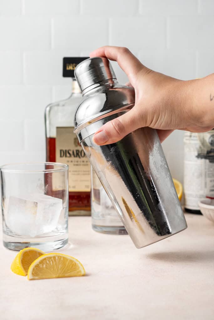 Shaking the amaretto sour in a cocktail shaker.