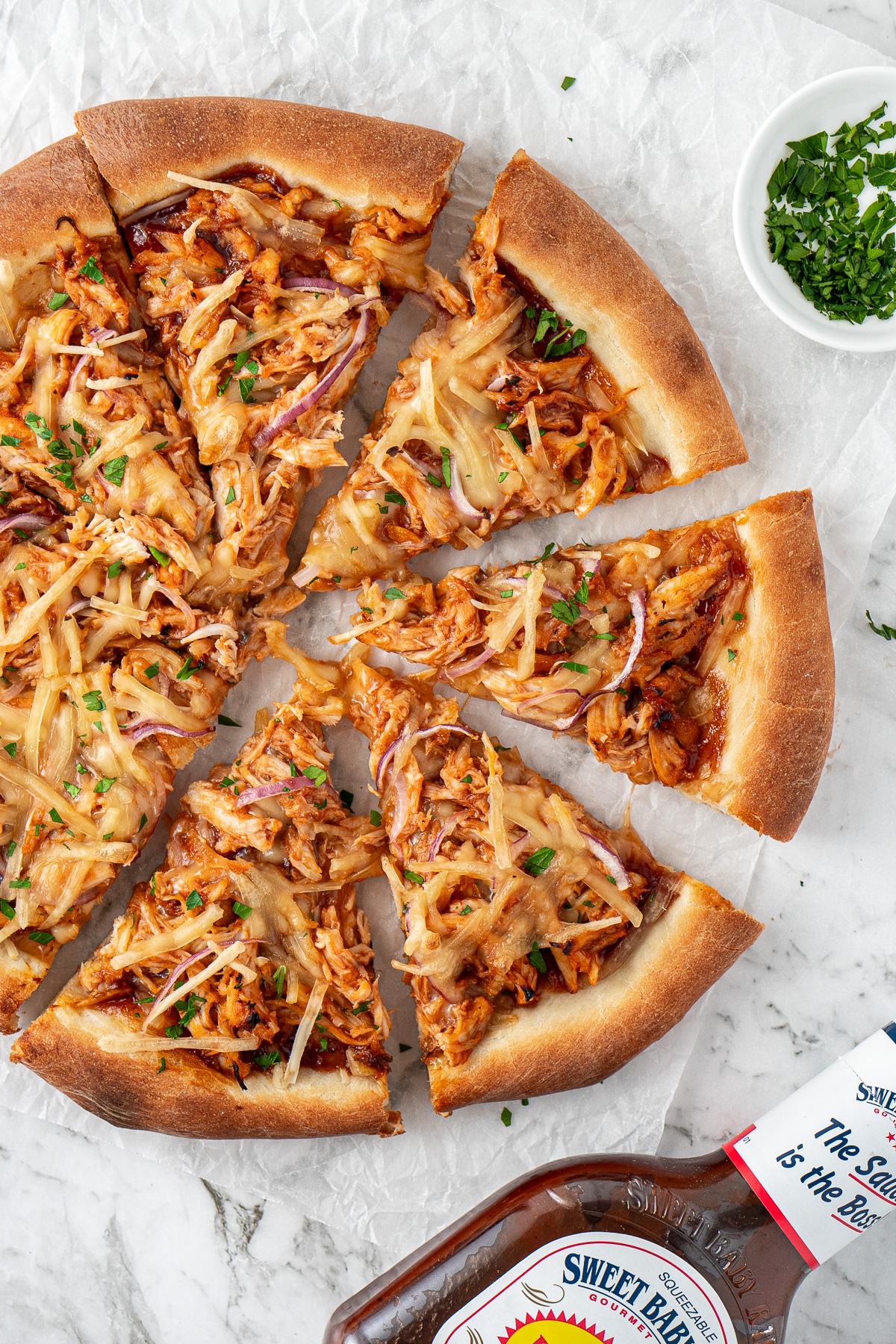 Close up of a barbeque chicken pizza sliced.