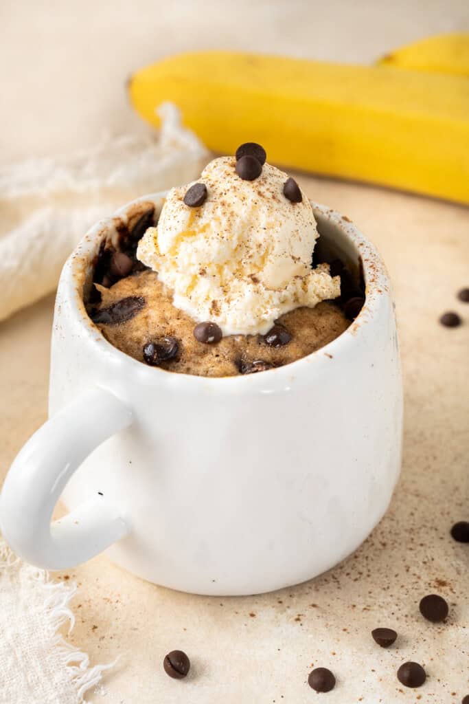 Cooked banana bread mug cake topped with ice cream.