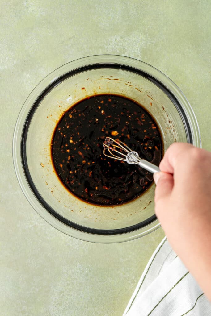 Whisking together the sauce in a small bowl.