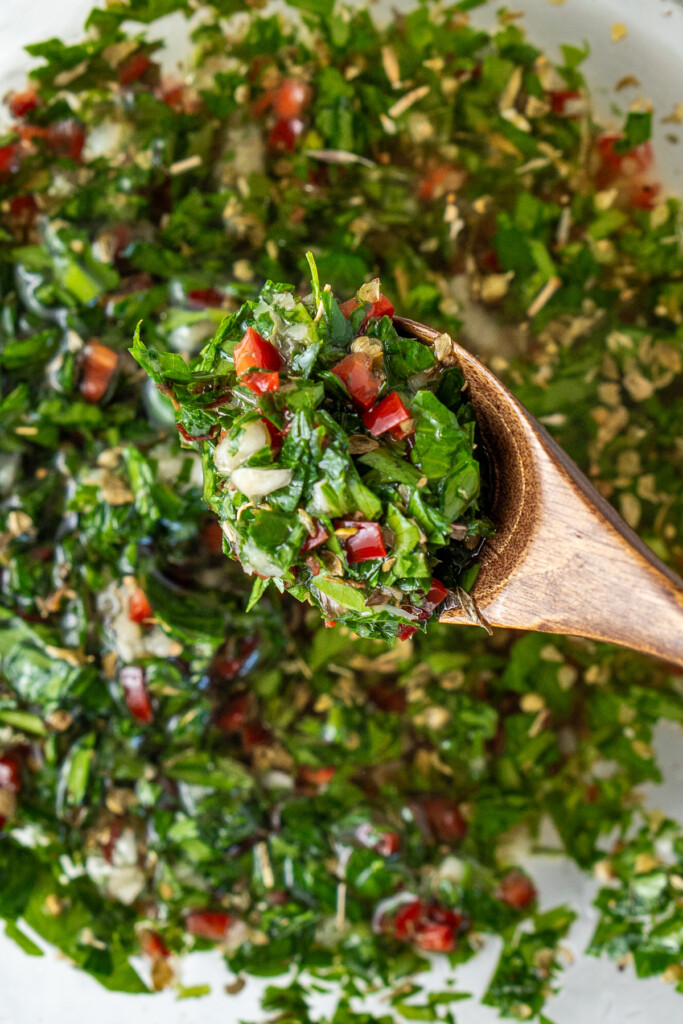 Close up of a spoon of chimichurri. 