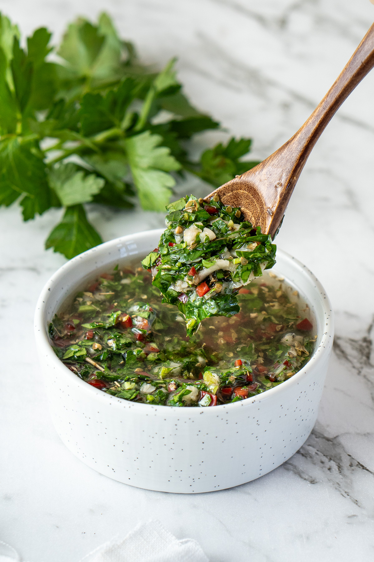 A spoon of freshly made chimichurri. 