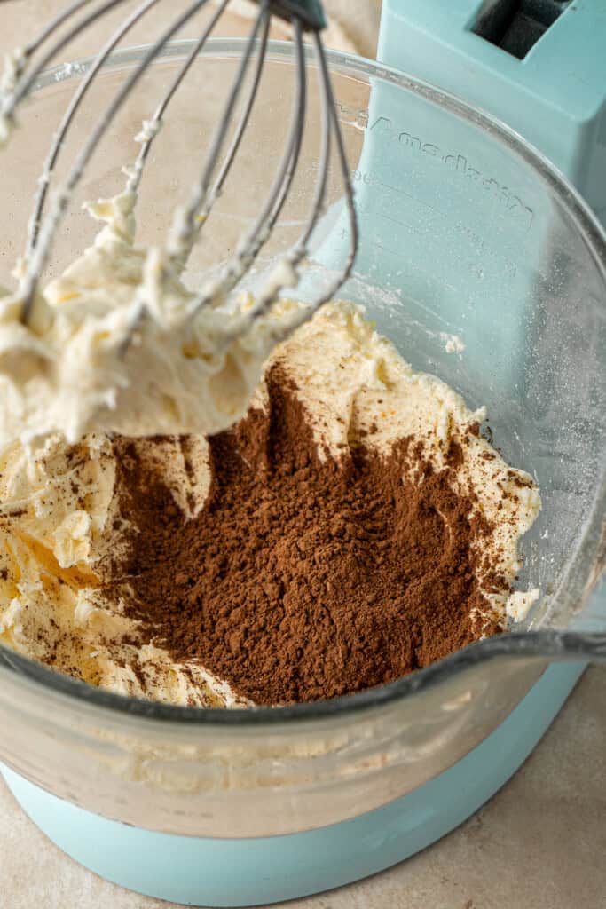 Adding the cocoa powder to the stand mixer.