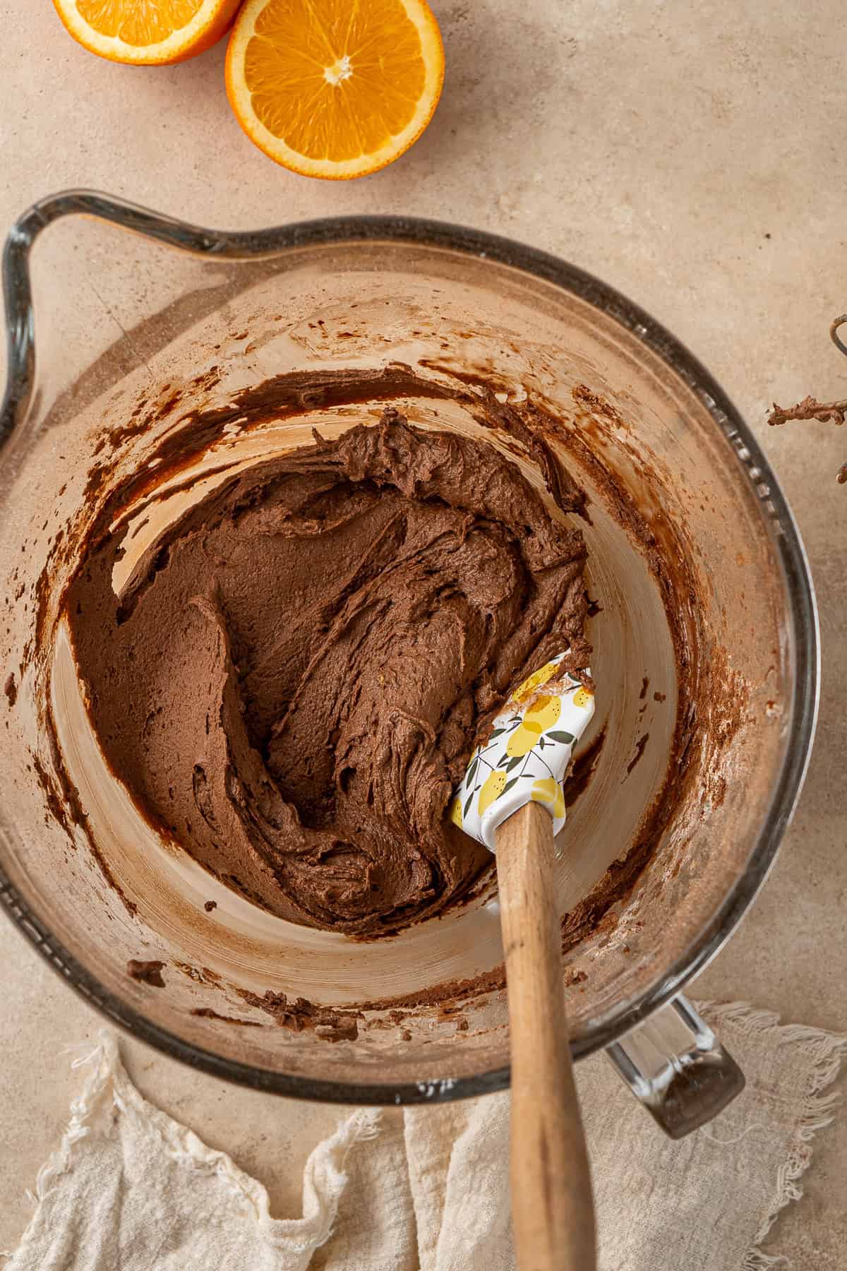 Thick and creamy chocolate orange buttercream in a bowl with a spatula. 