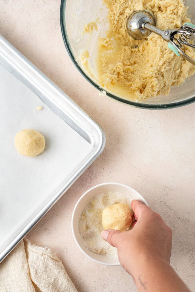 Rolling balls of cookie dough in lemon sugar.