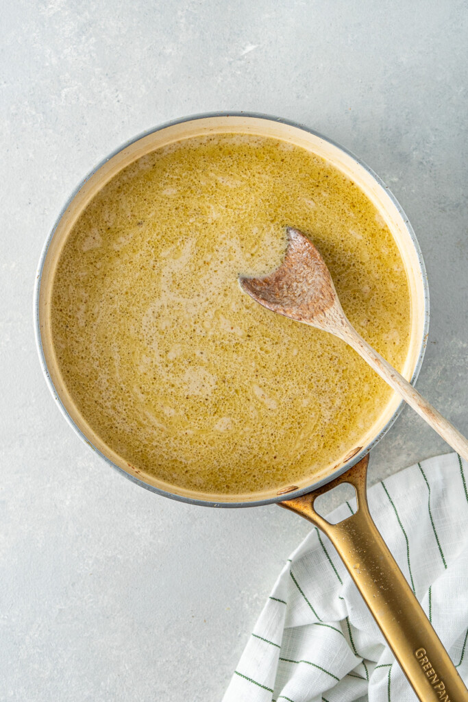 Mixing the coconut milk in the pan to make the curry sauce.