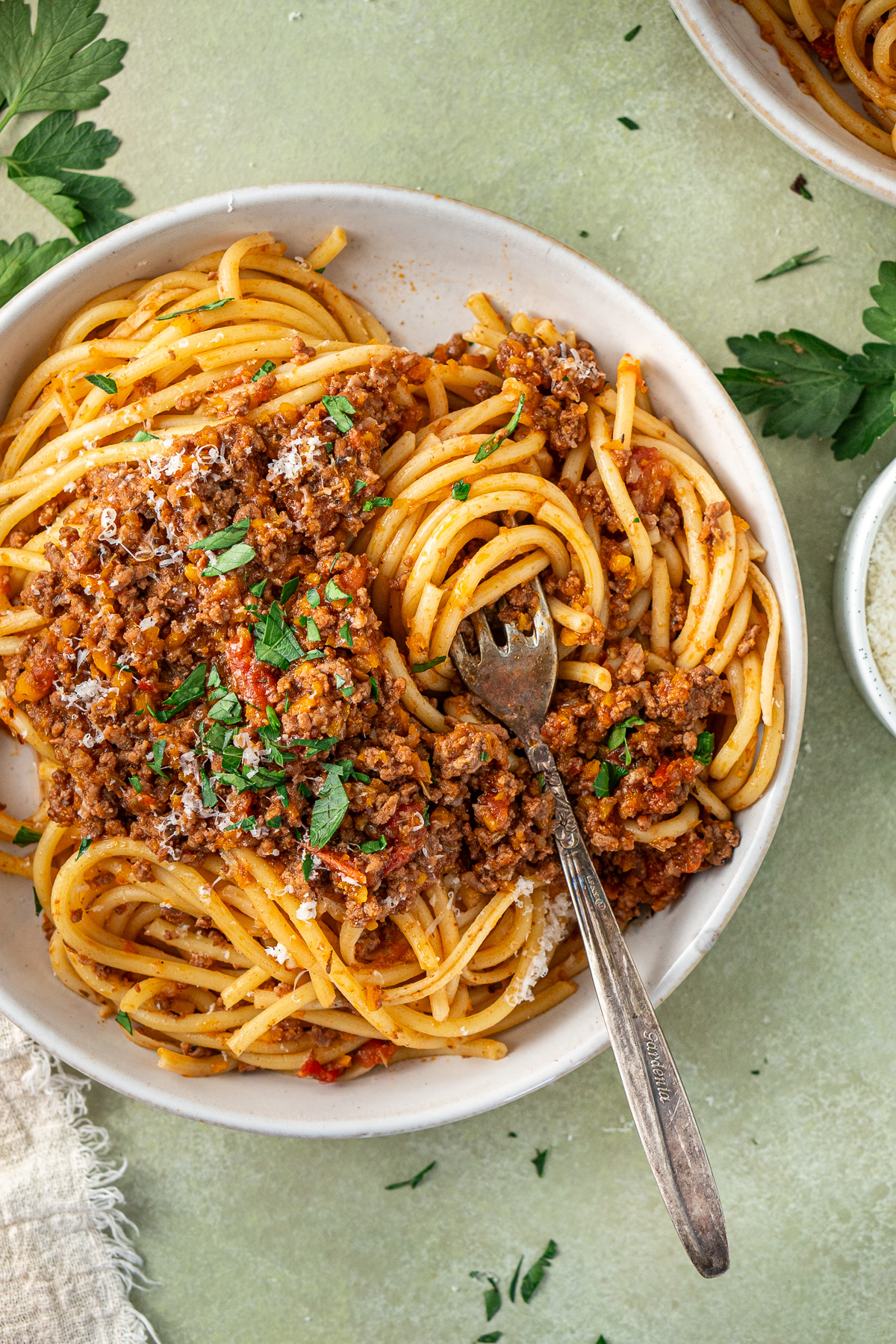 Close up of a fork twirling a piece of spaghetti bolognese. 