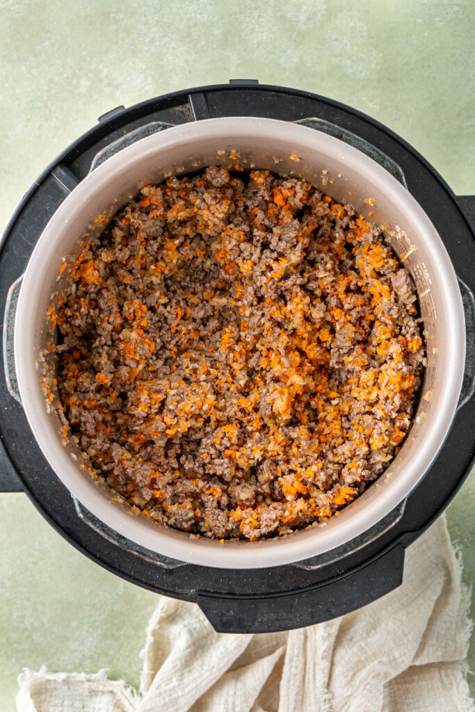 The browned mince with the vegetables in the slow cooker.