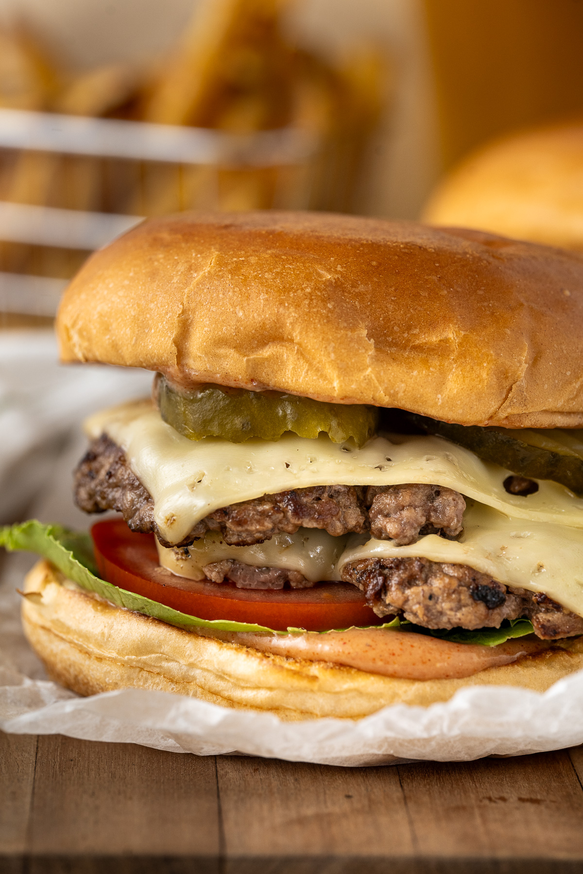 Close up of a double staked smash burger with cheese and pickles.