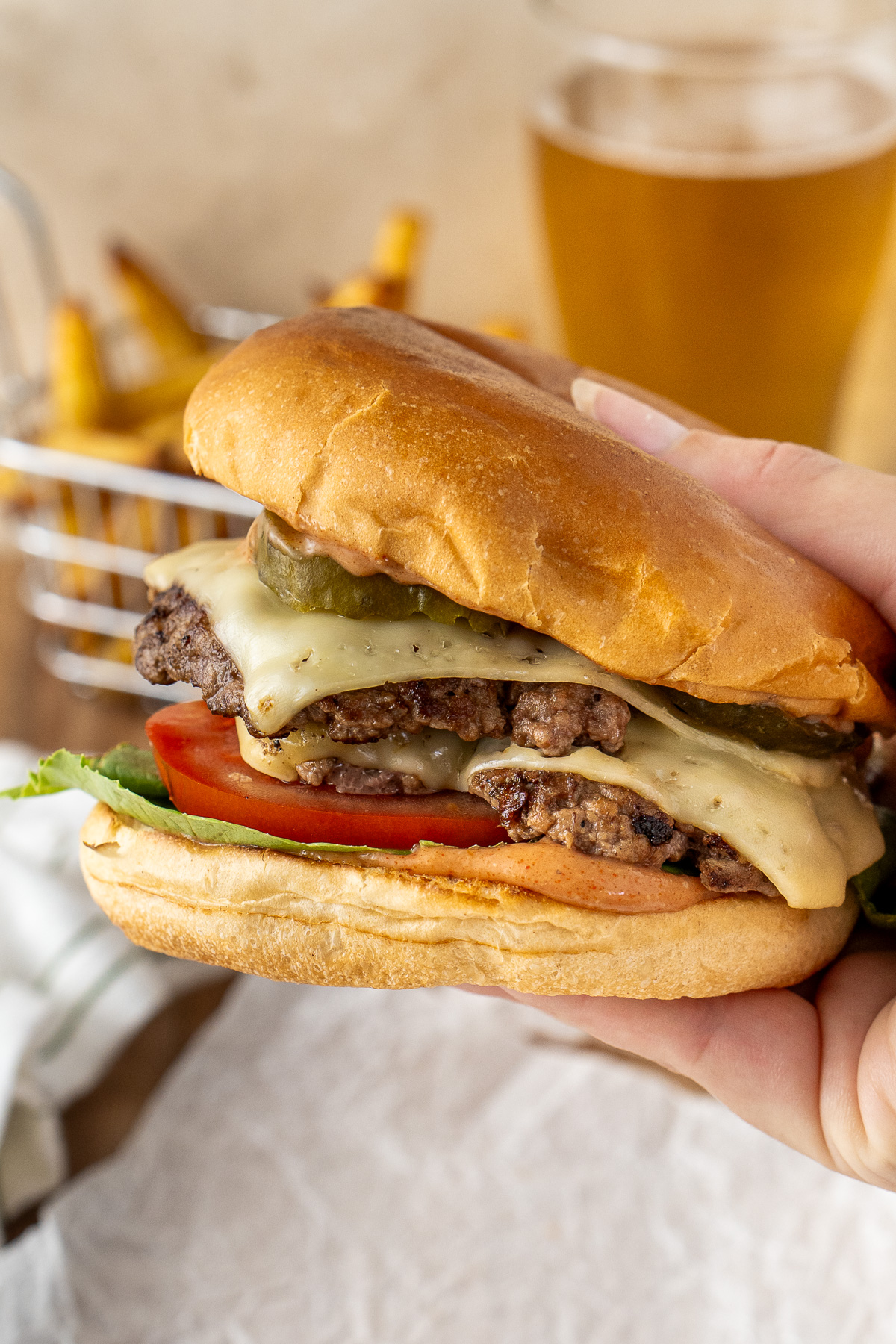 A hand picking up a smash burger.