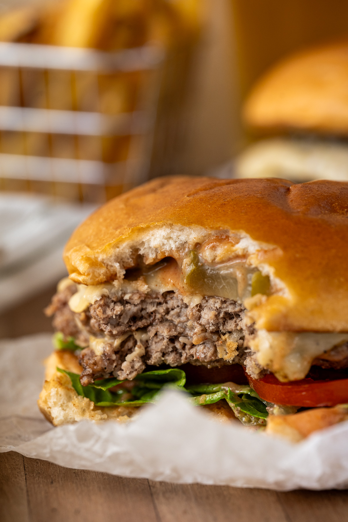 A close up of a smash burger with a bite taken.