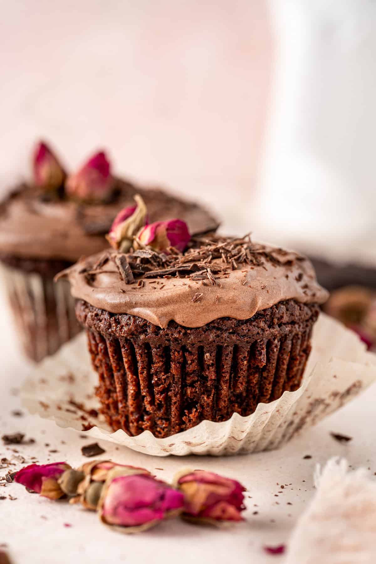 Close up of a chocolate cupcake with the liner pulled down.