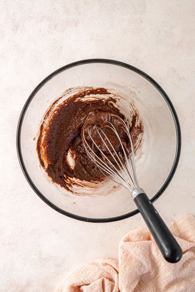 Whisking together the chocolate cupcakes batter in a bowl.