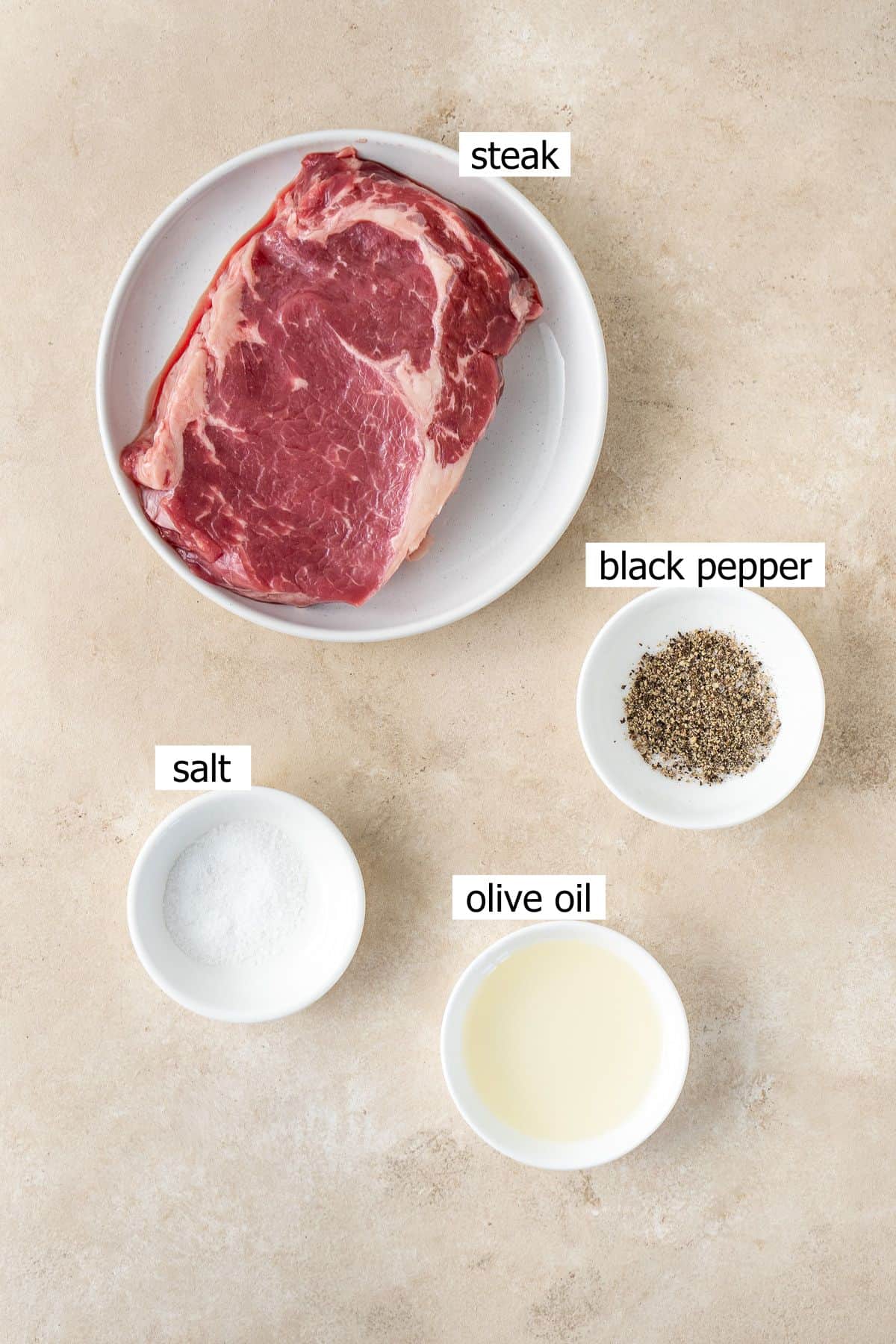 All ingredients needed to make air fryer steak laid out in bowls.