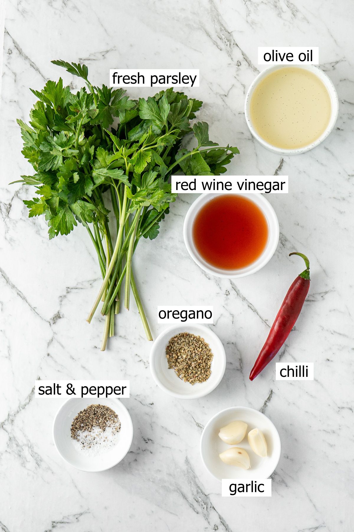 All ingredients needed to make easy chimichurri laid out in bowls.