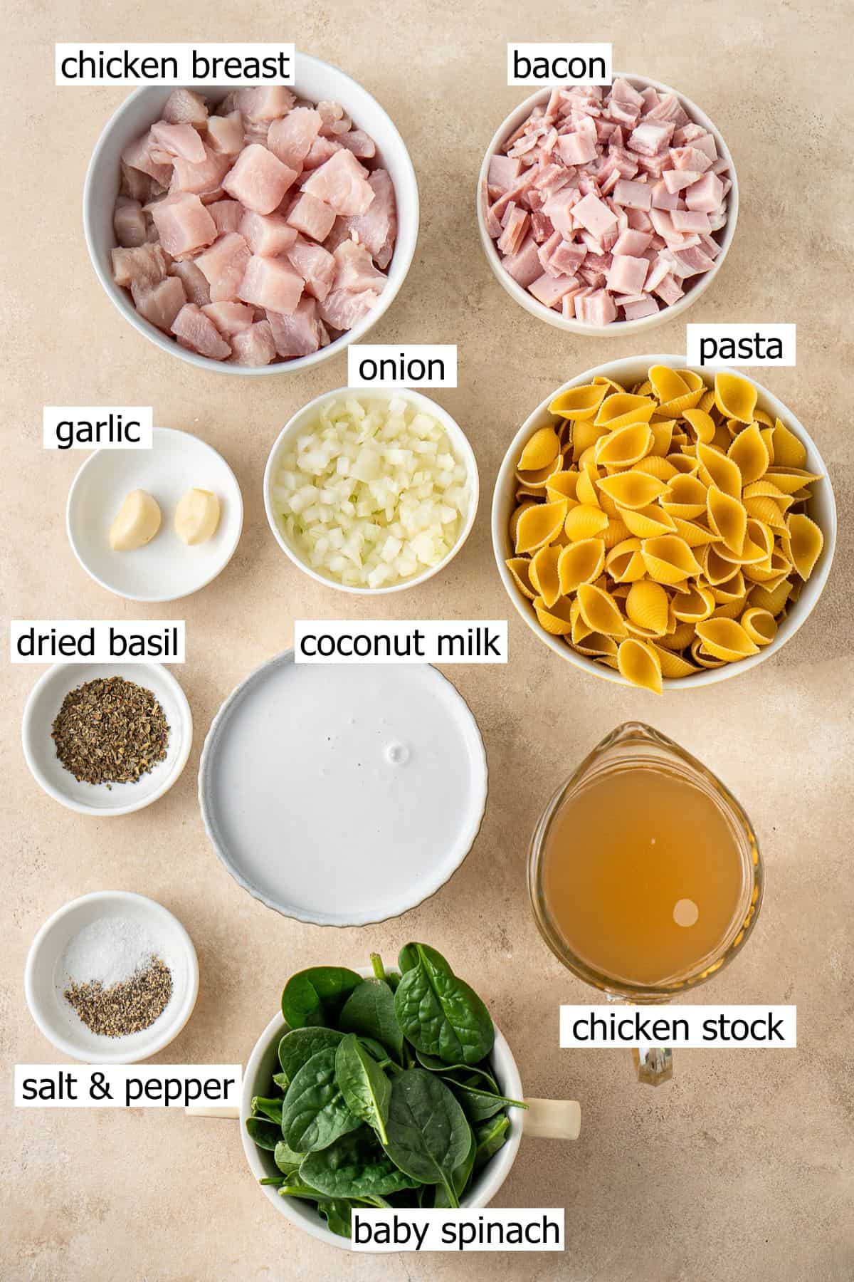 All ingredients needed to make dairy free creamy chicken bacon pasta laid out in small bowls.