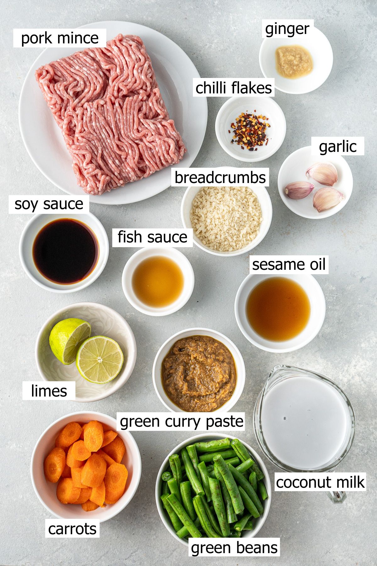 All ingredients needed to make green curry meatballs laid out in small bowls.