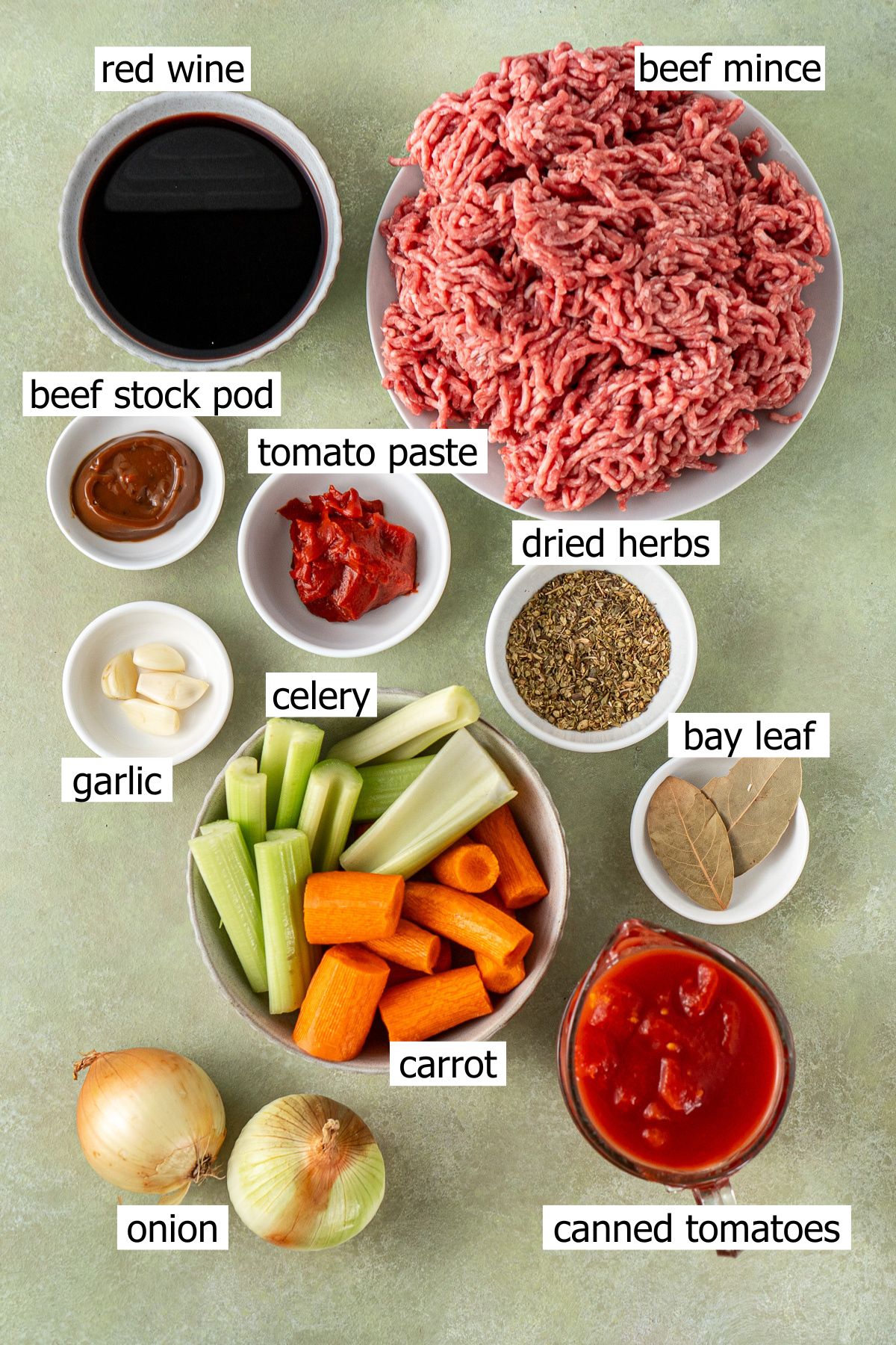 All ingredients needed to make slow cooker bolognese laid out in small bowls.