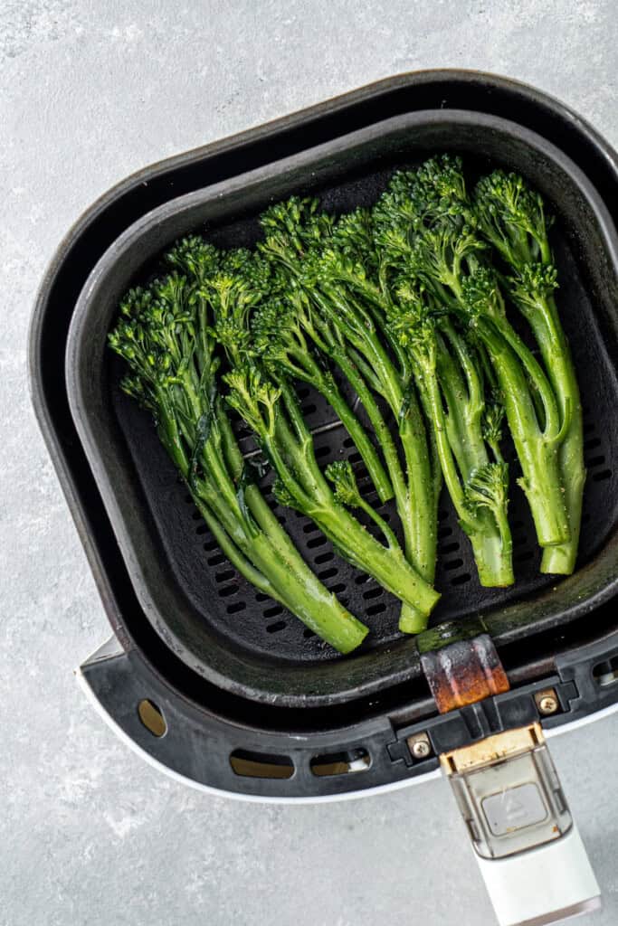 Broccolini in the air fryer basket.