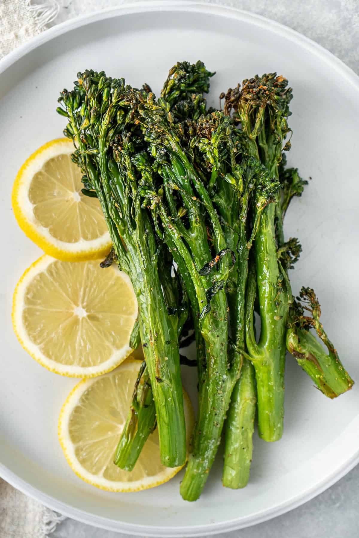 Air fryer broccolini served on a plate with lemon.