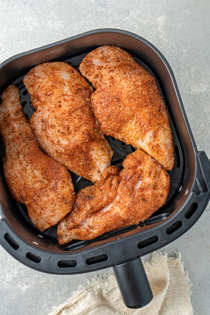 Chicken breast fillets in the air fryer basket.