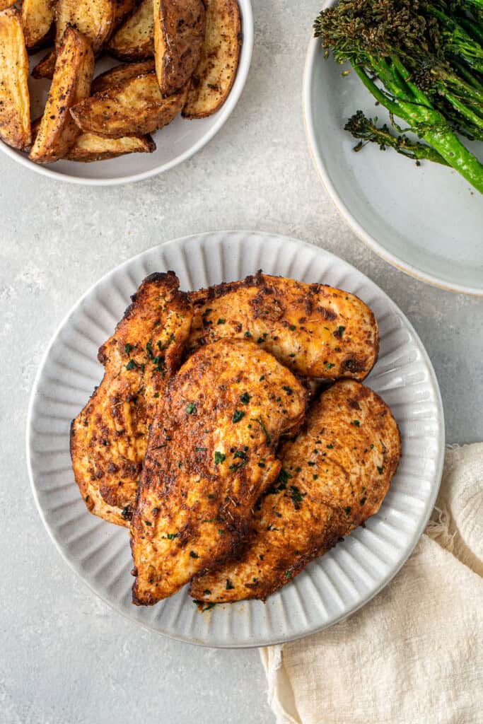 Cooked chicken breast on a plate with sides.