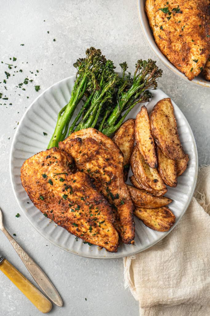 Air fryer chicken breast with broccolini and wedges.