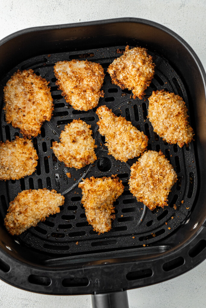 Crispy air fried nuggets in the basket of the air fryer.