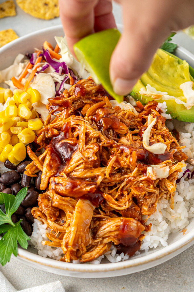 Squeezing a wedge of lime over the BBQ chicken.