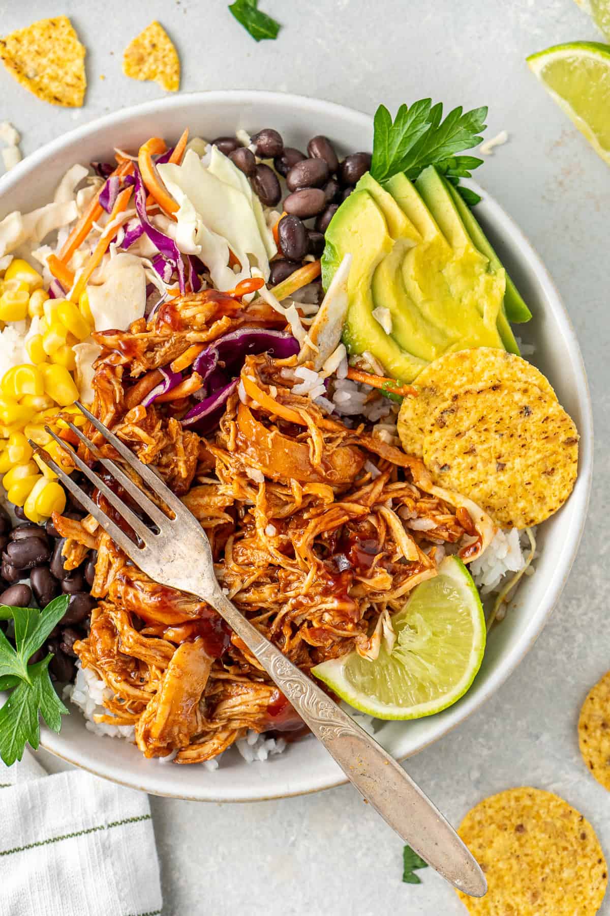 Close up of a colourful BBQ chicken bowl with a fork.