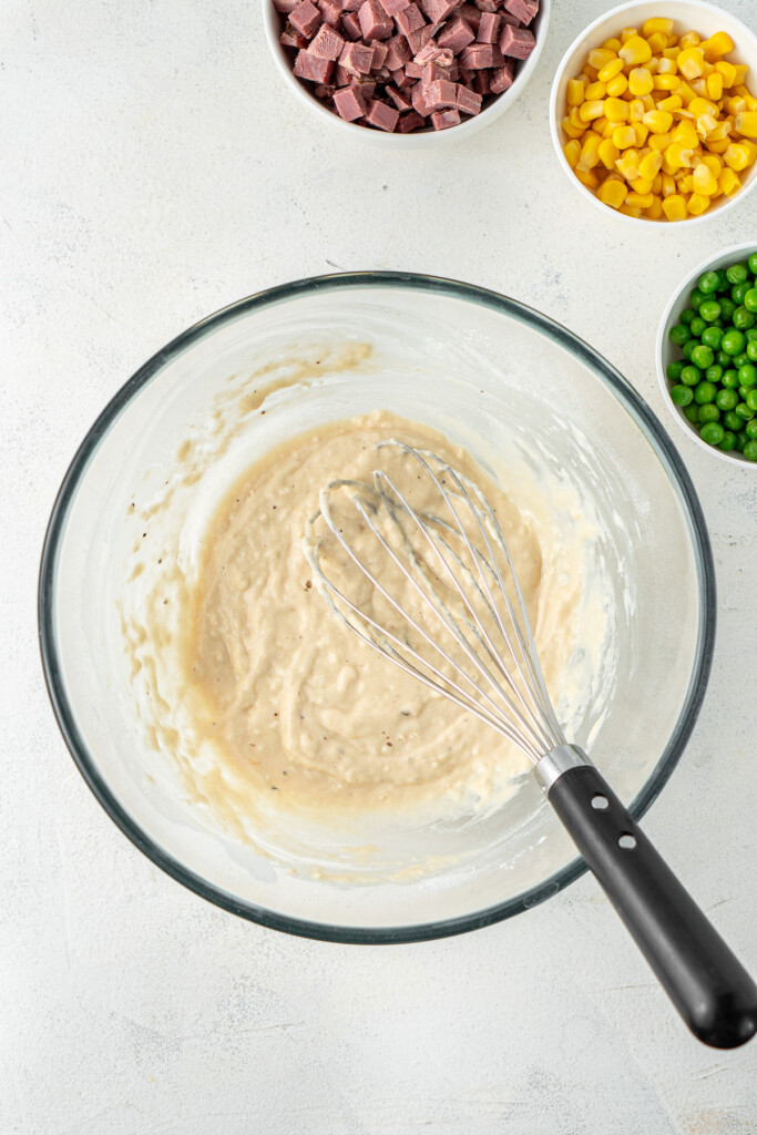 Whisking together the fritter batter in a bowl.