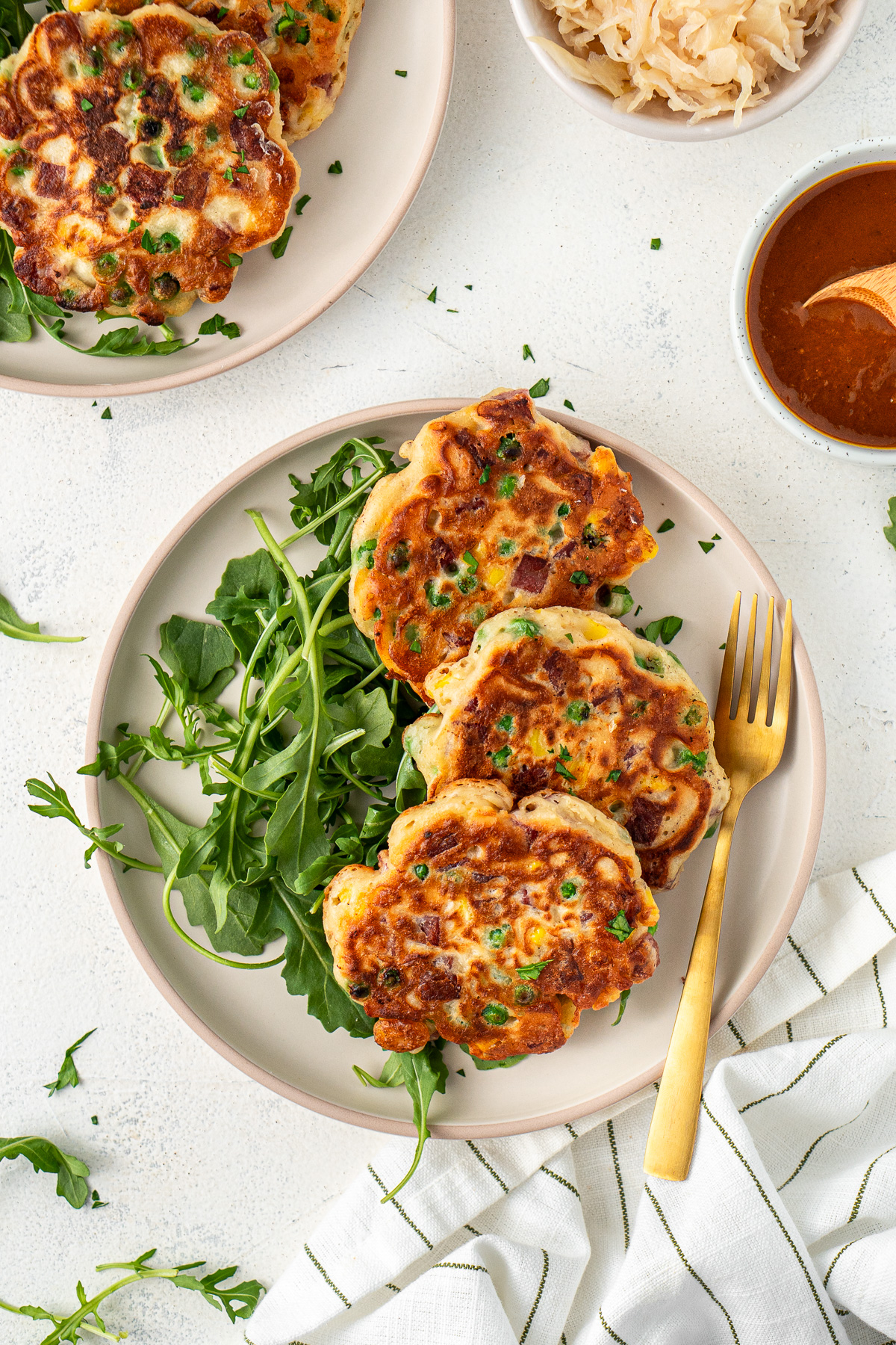 Corned beef fritters on a plate with salad and a fork.