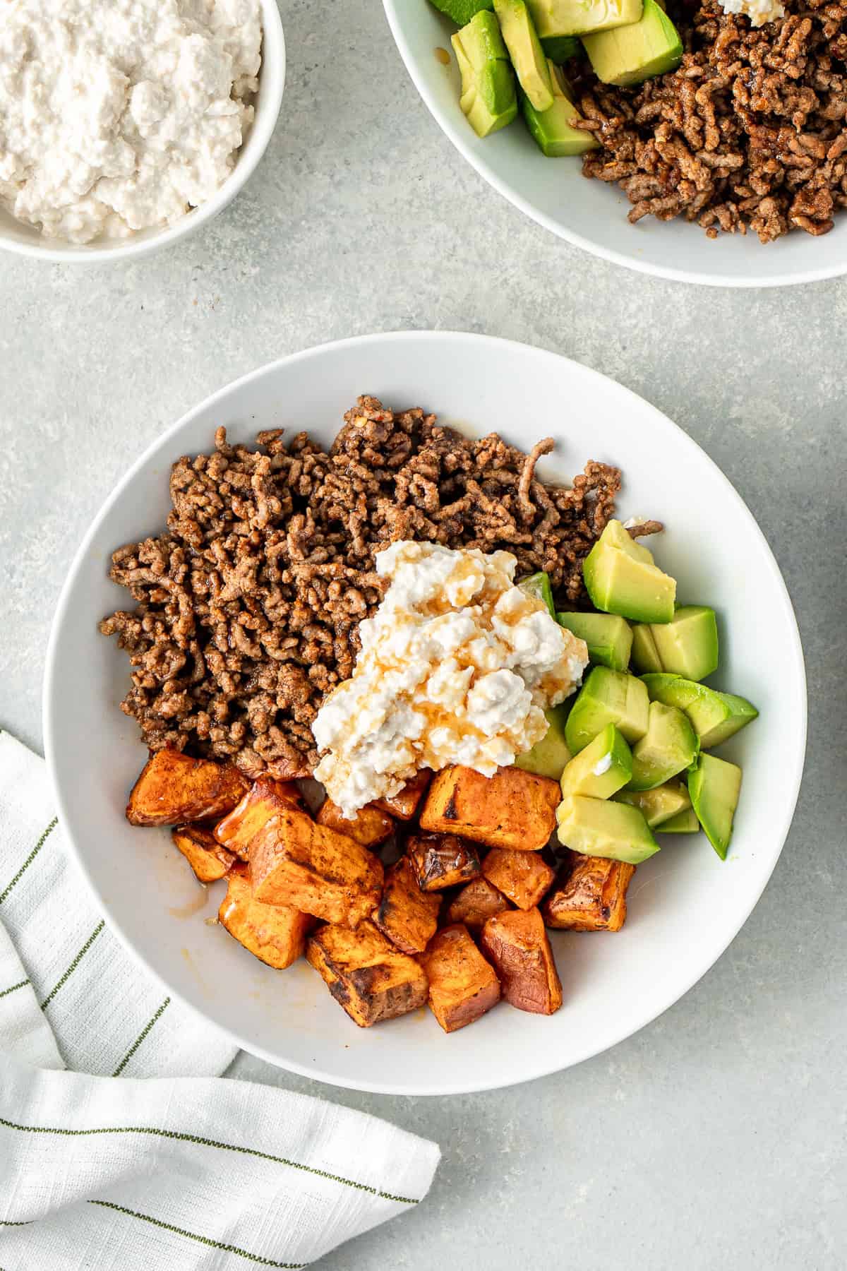 Sweet potato, beef mince, avocado and dairy free cottage cheese in a bowl topped with hot honey.