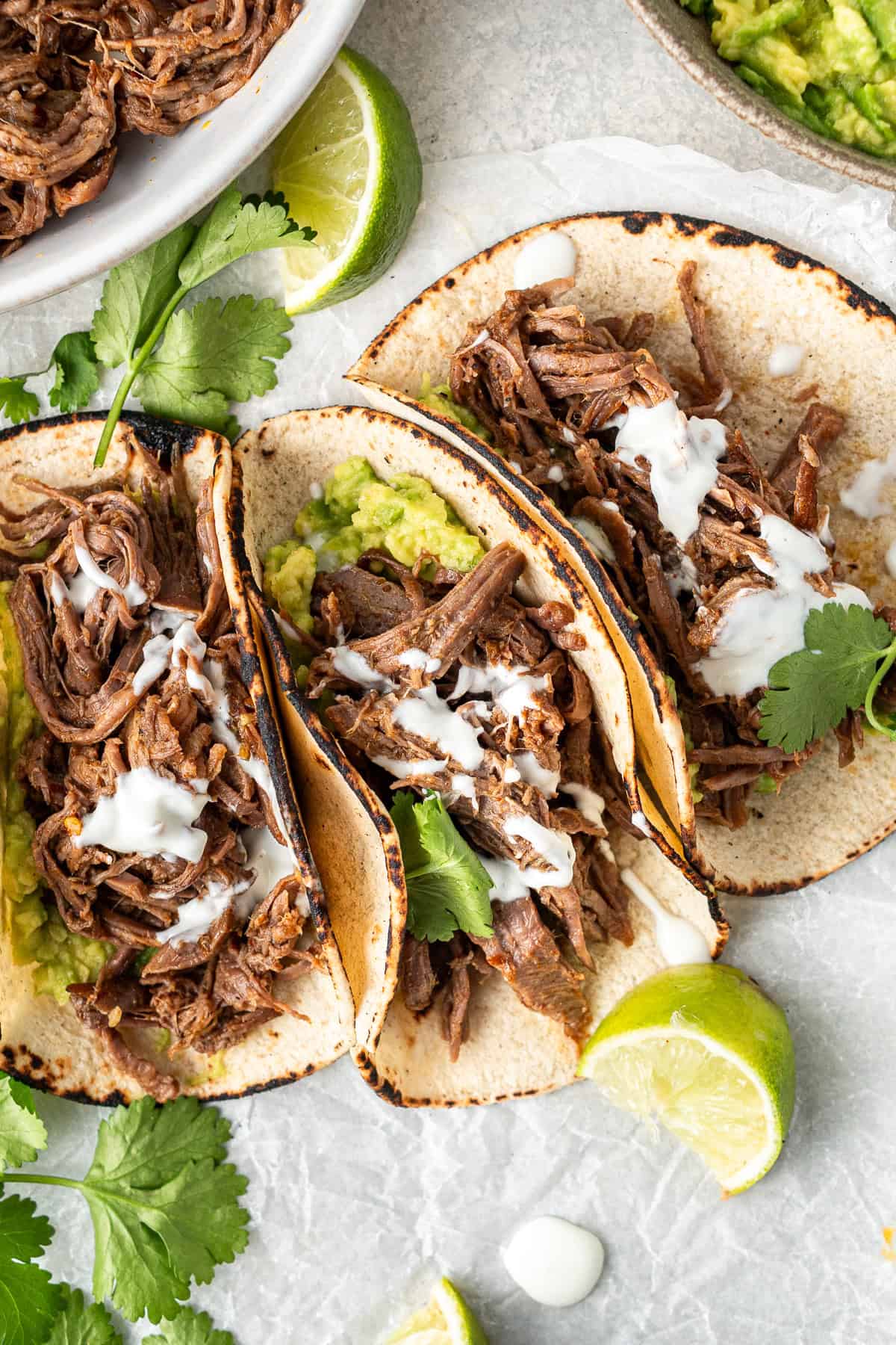 Three shredded beef tacos with avocado and dairy free yoghurt. 