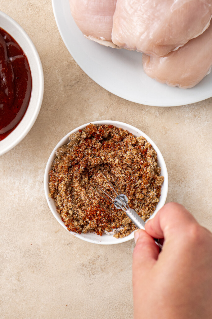 Mixing together spices in a bowl.