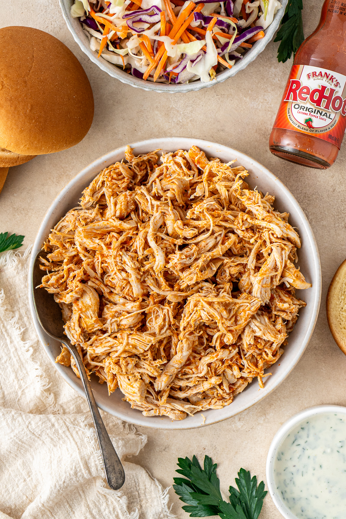 Shredded slow cooked buffalo chicken in a bowl.