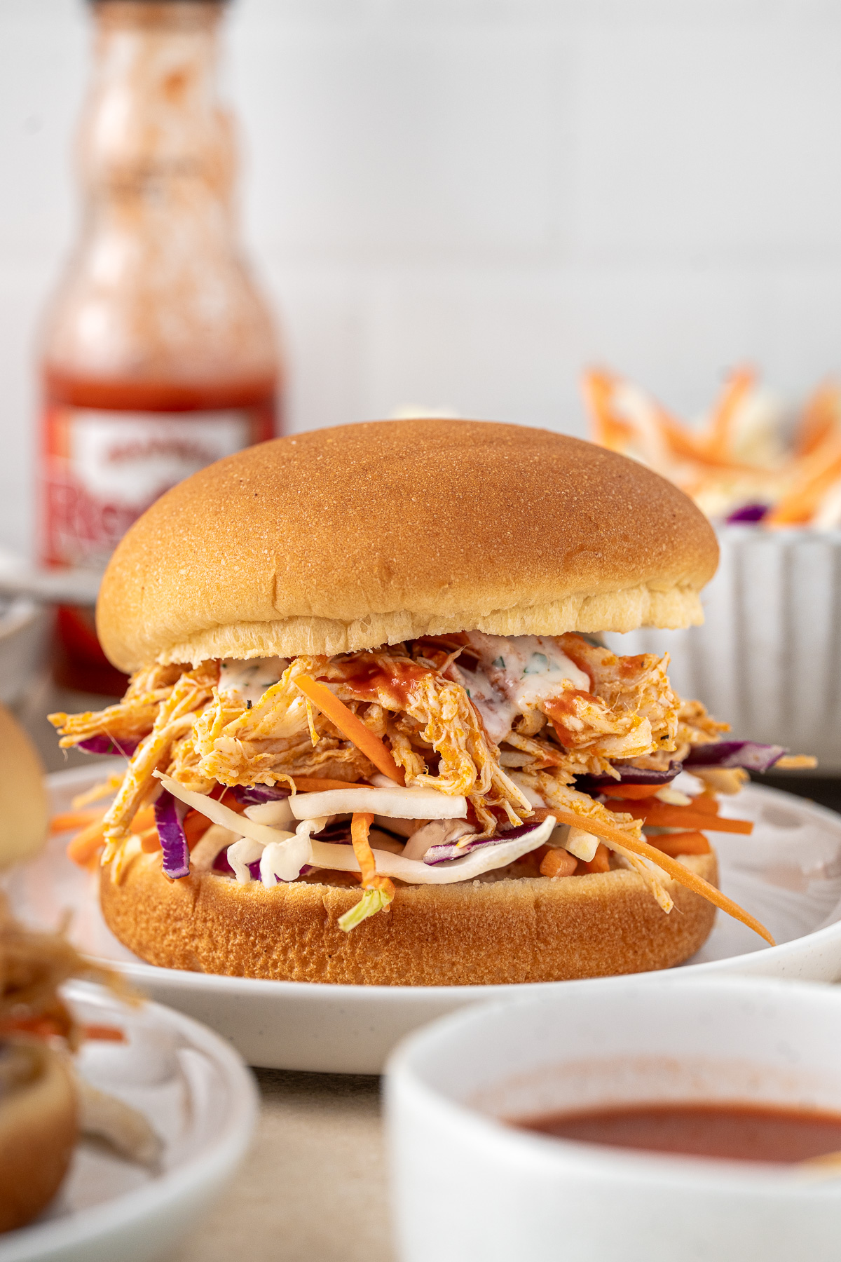 Serving suggestion of a buffalo chicken sandwich with coleslaw.