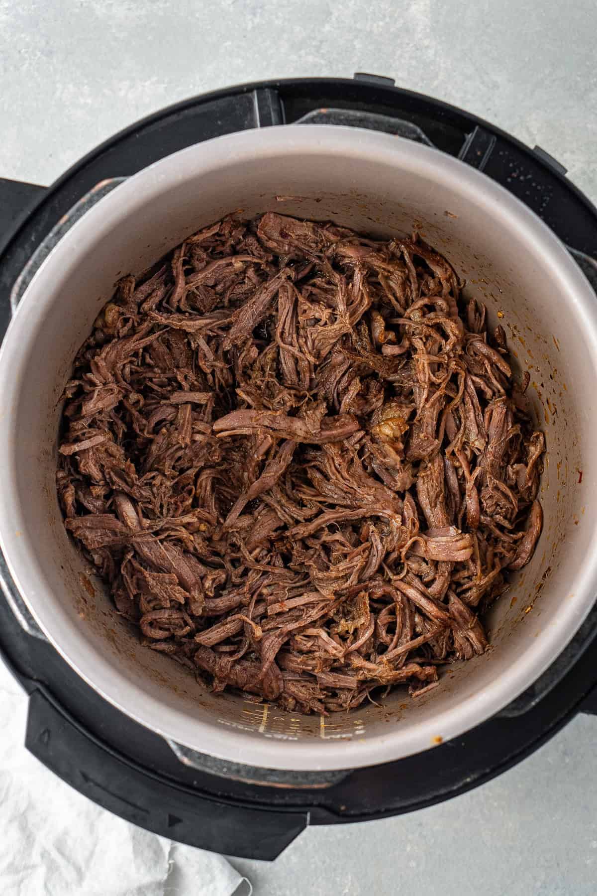 Close up of the shredded mexican beef in the slow cooker.