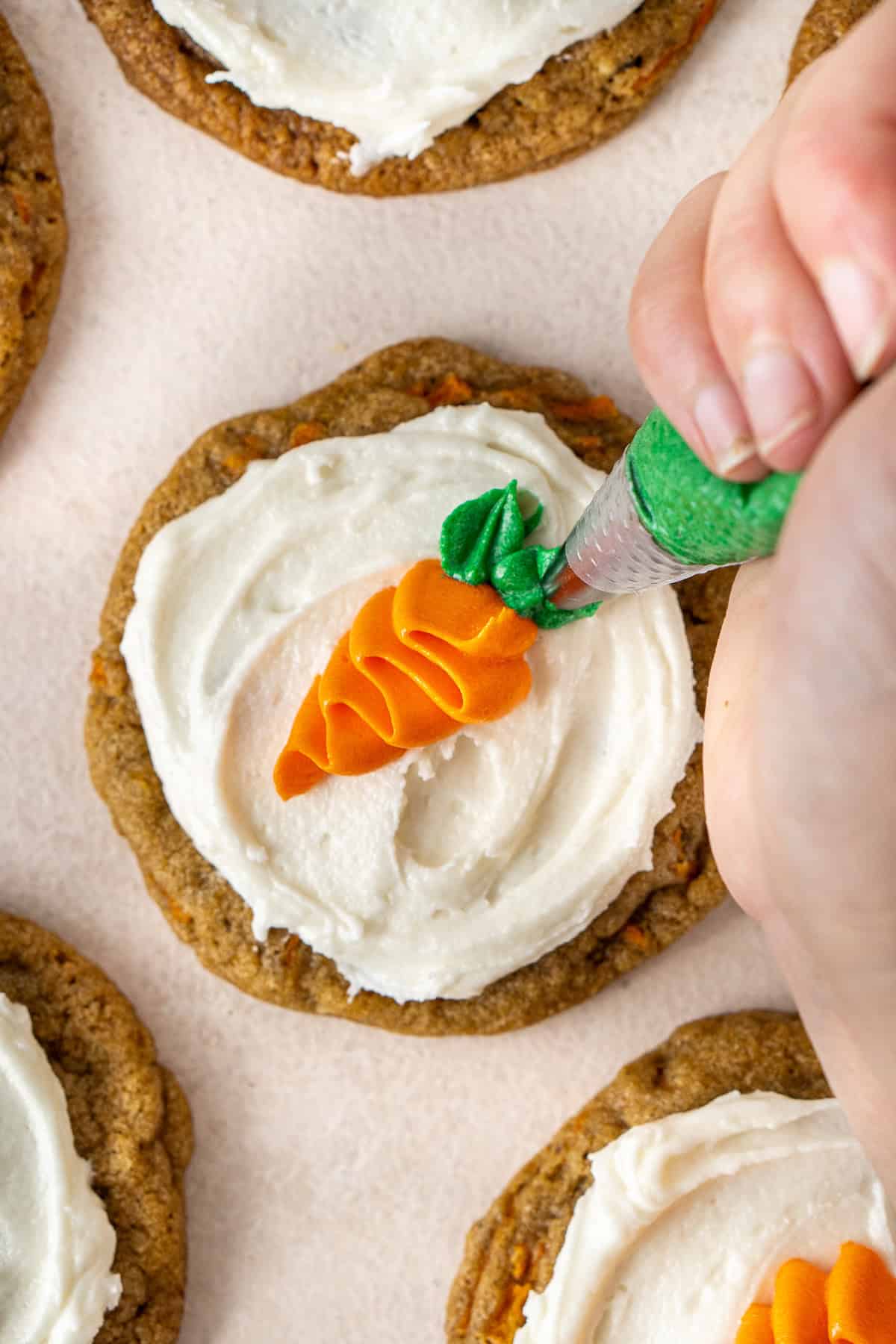 Piping the carrot leaves on the cookies.
