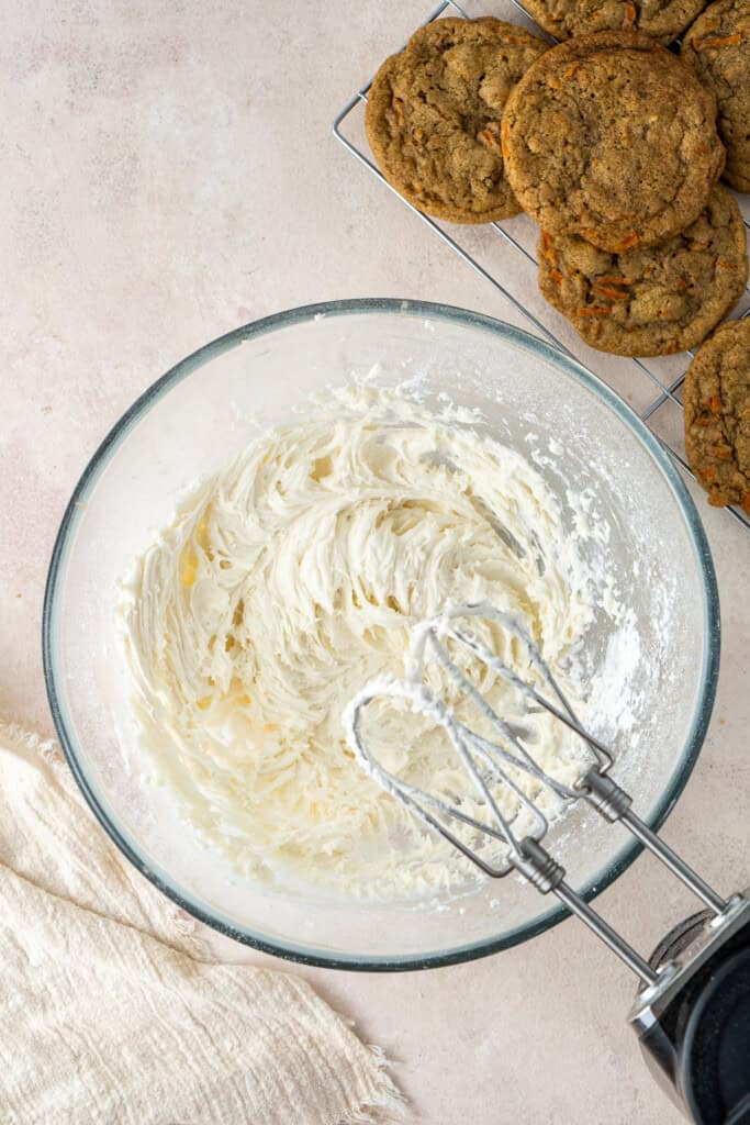 Making the buttercream in a bowl with a mixer.