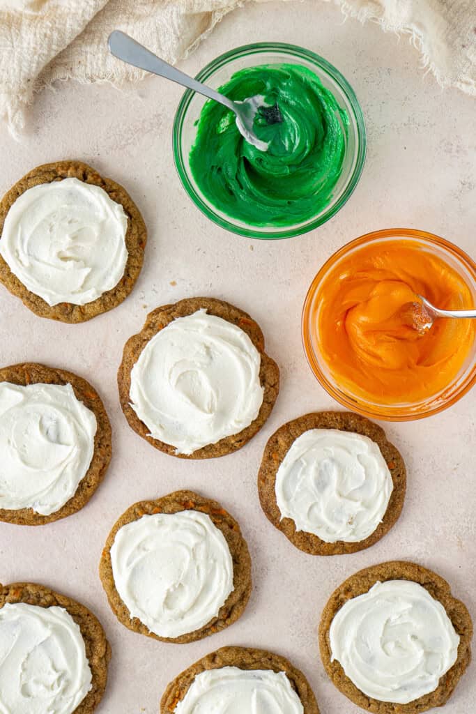The frosted cookies with tinted buttercream in bowls.