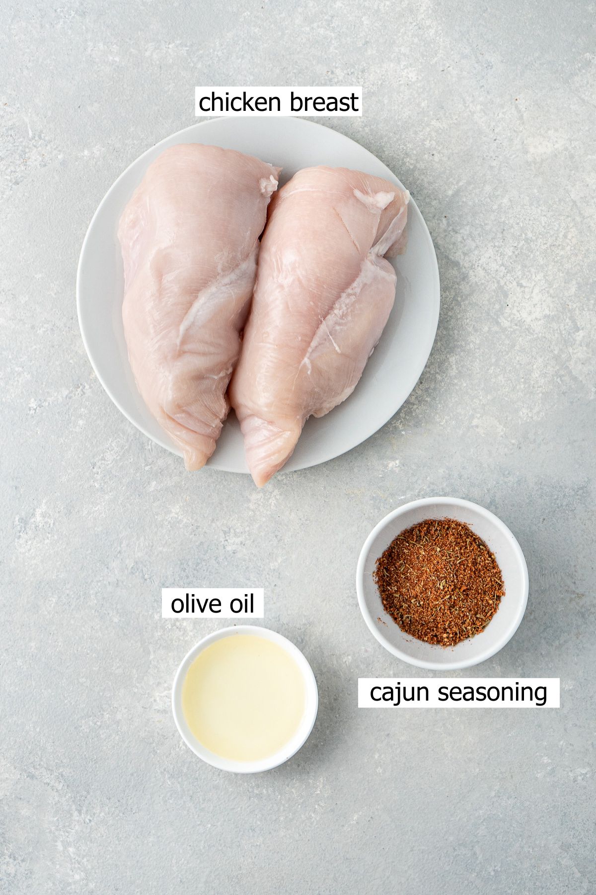 All ingredients needed to make air fryer chicken breast laid out in bowls.