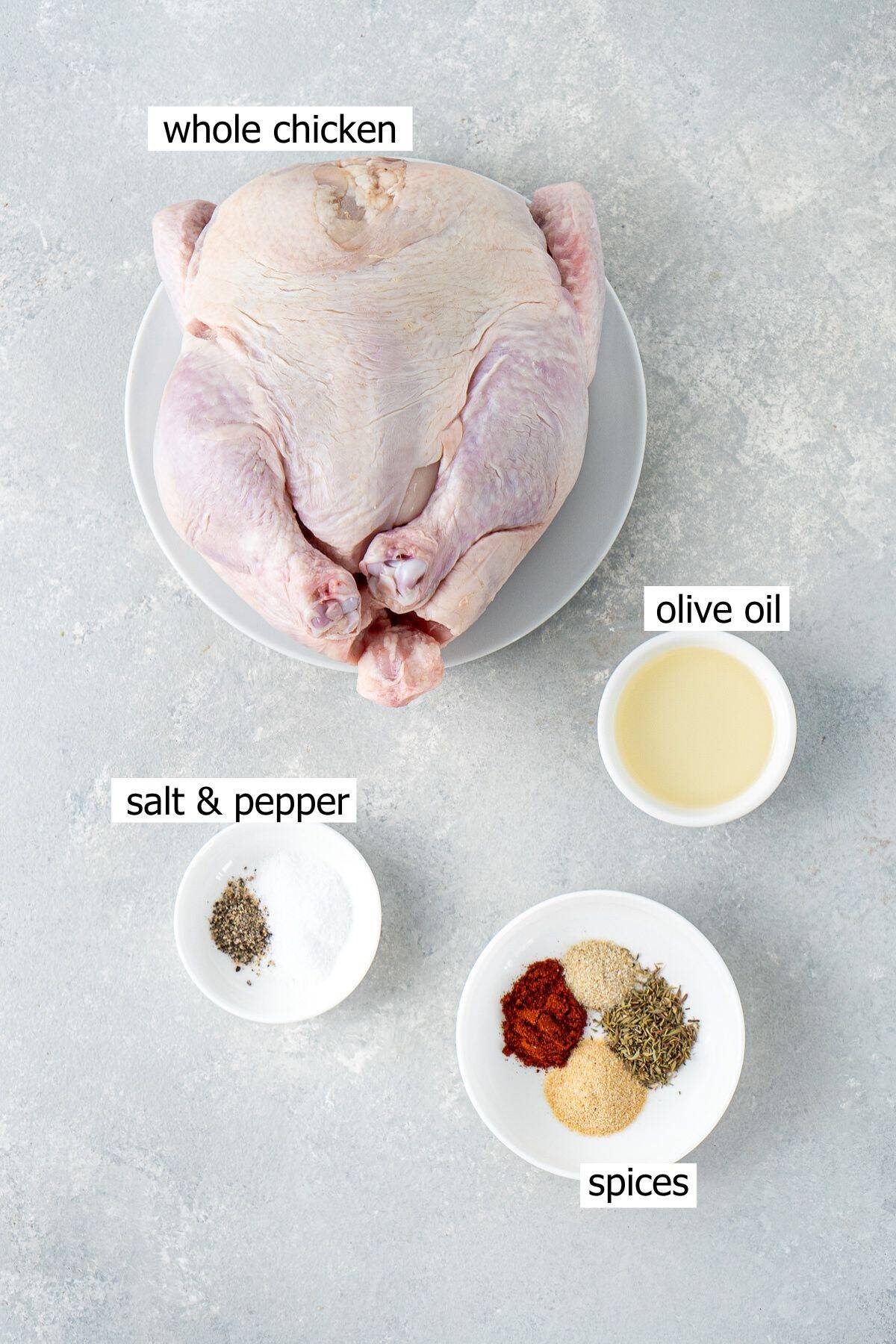 All ingredients needed to make air fryer roast chicken laid out in bowls.