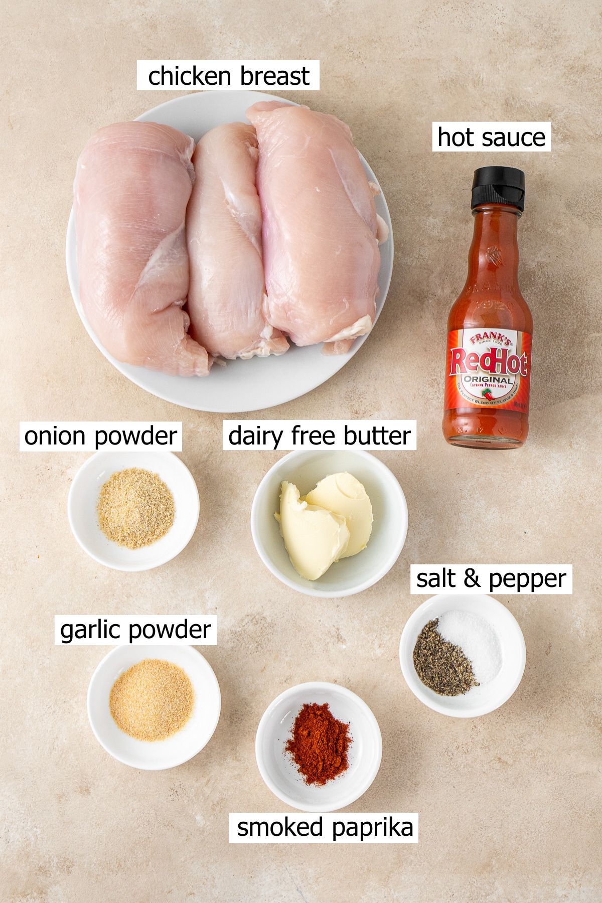 All ingredients needed for slow cooker buffalo chicken laid out in small bowls.